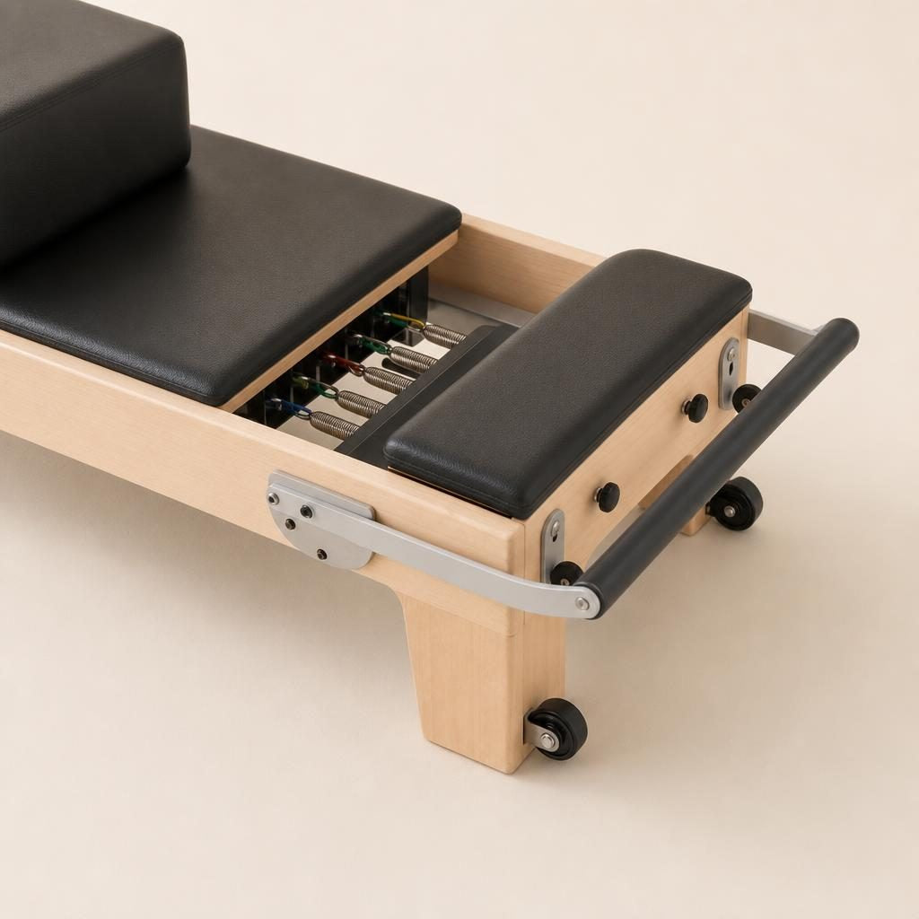 Détail de la barre de pieds, des ressorts et de la roulette du Reformer Studio Orin